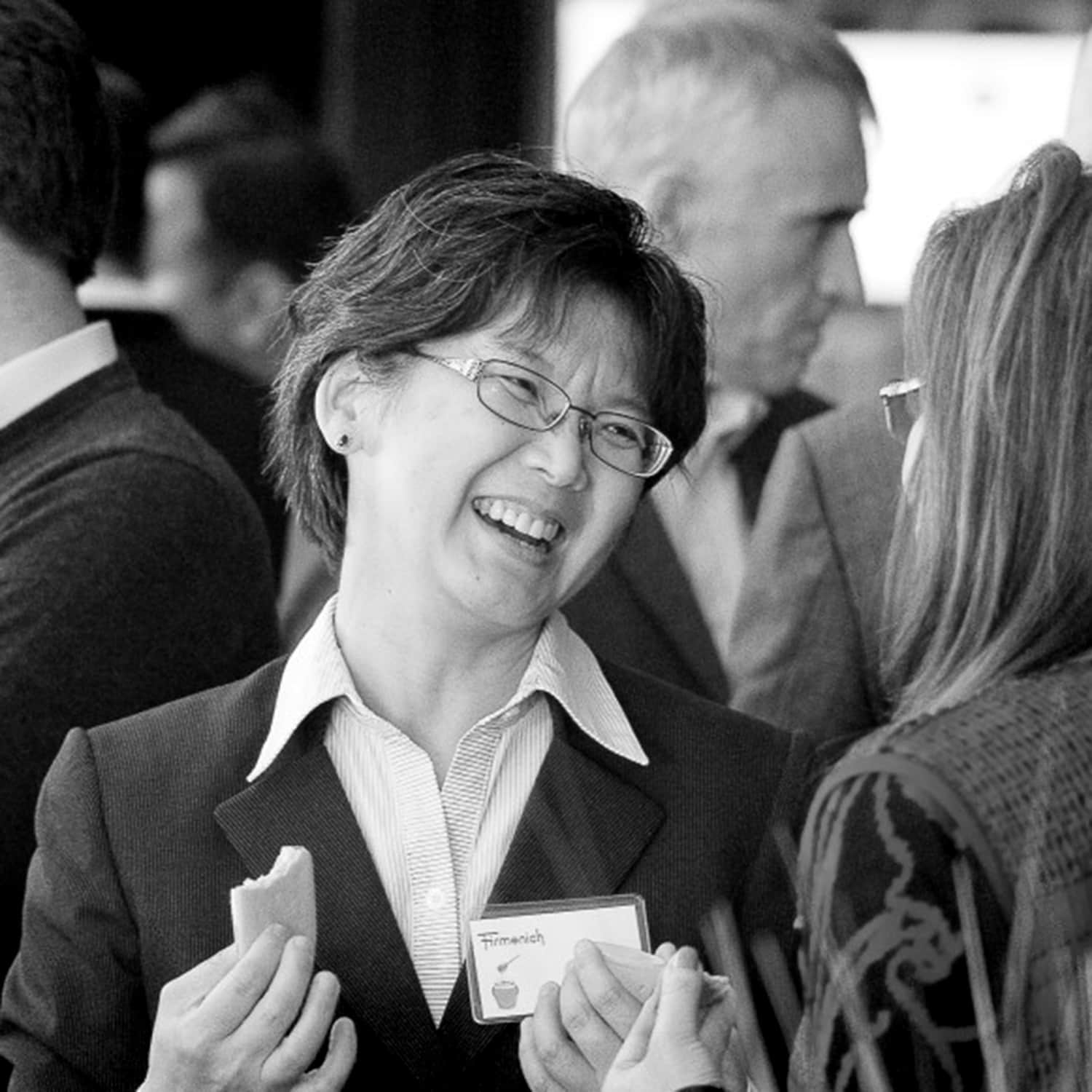 Woman laughing while talking at cooperate event