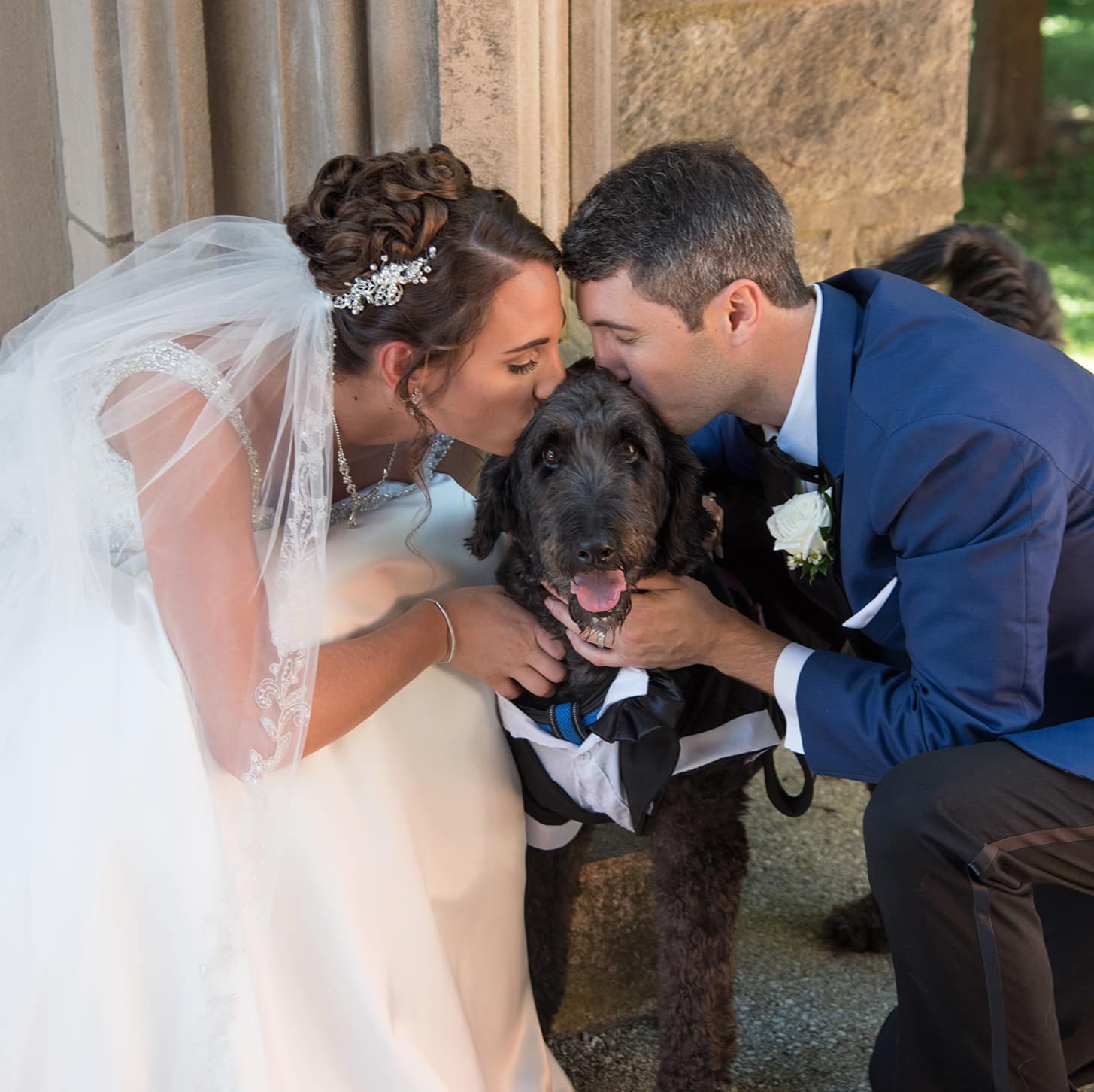 Wedding photo with couple kissing dog