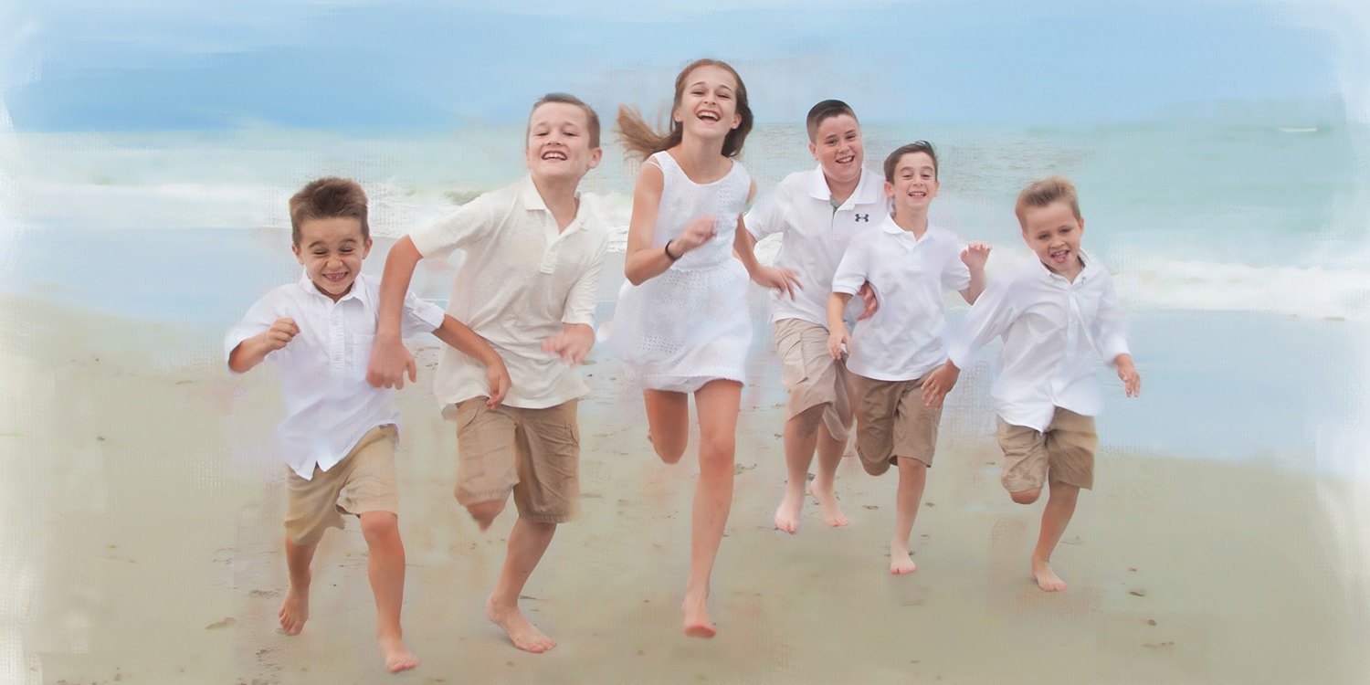 Portrait of children running on ocean beach