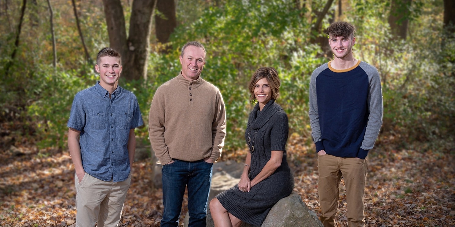 Portrait of family standing in a green forest