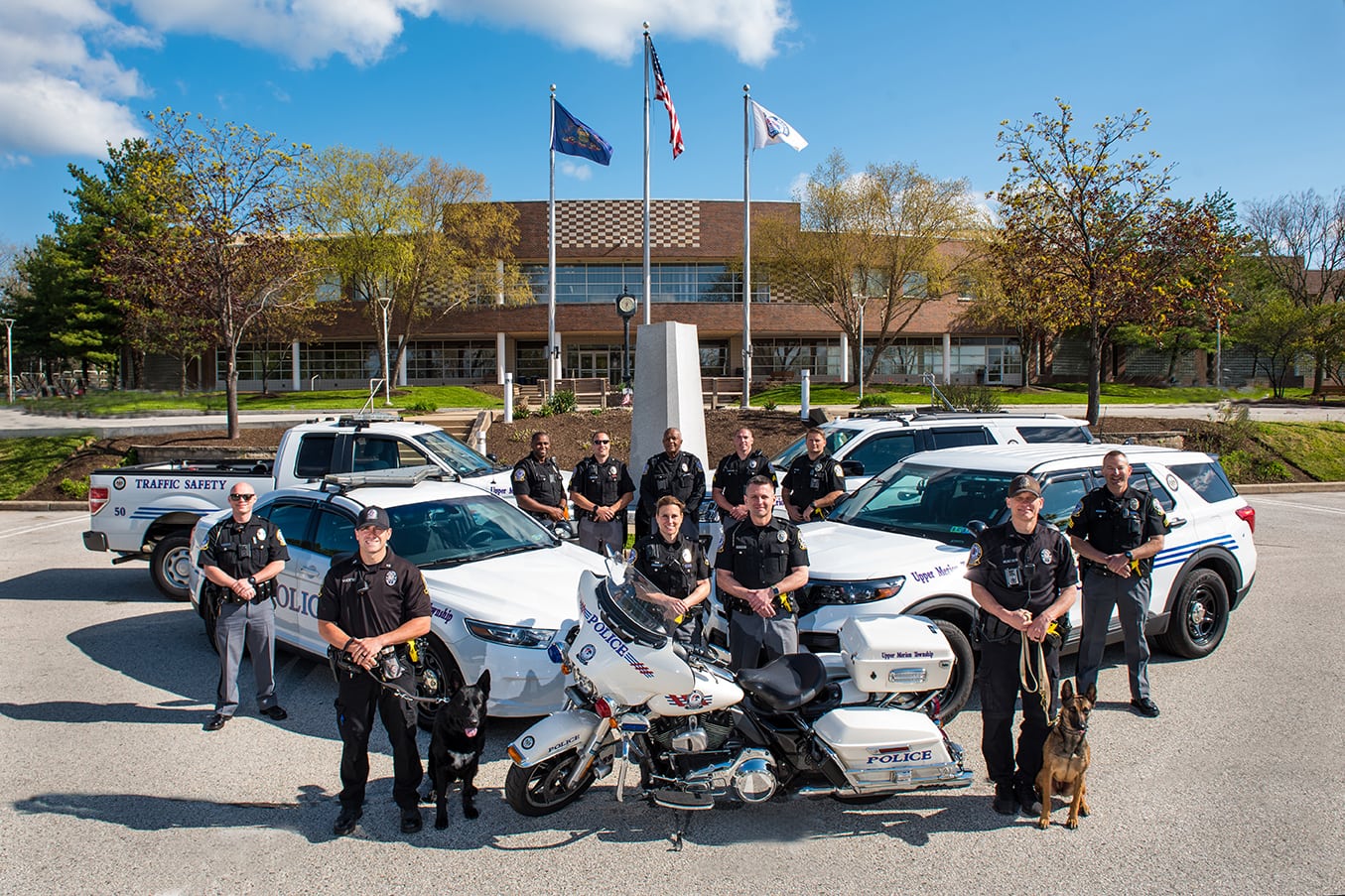 Police department posing in front of vehicles  